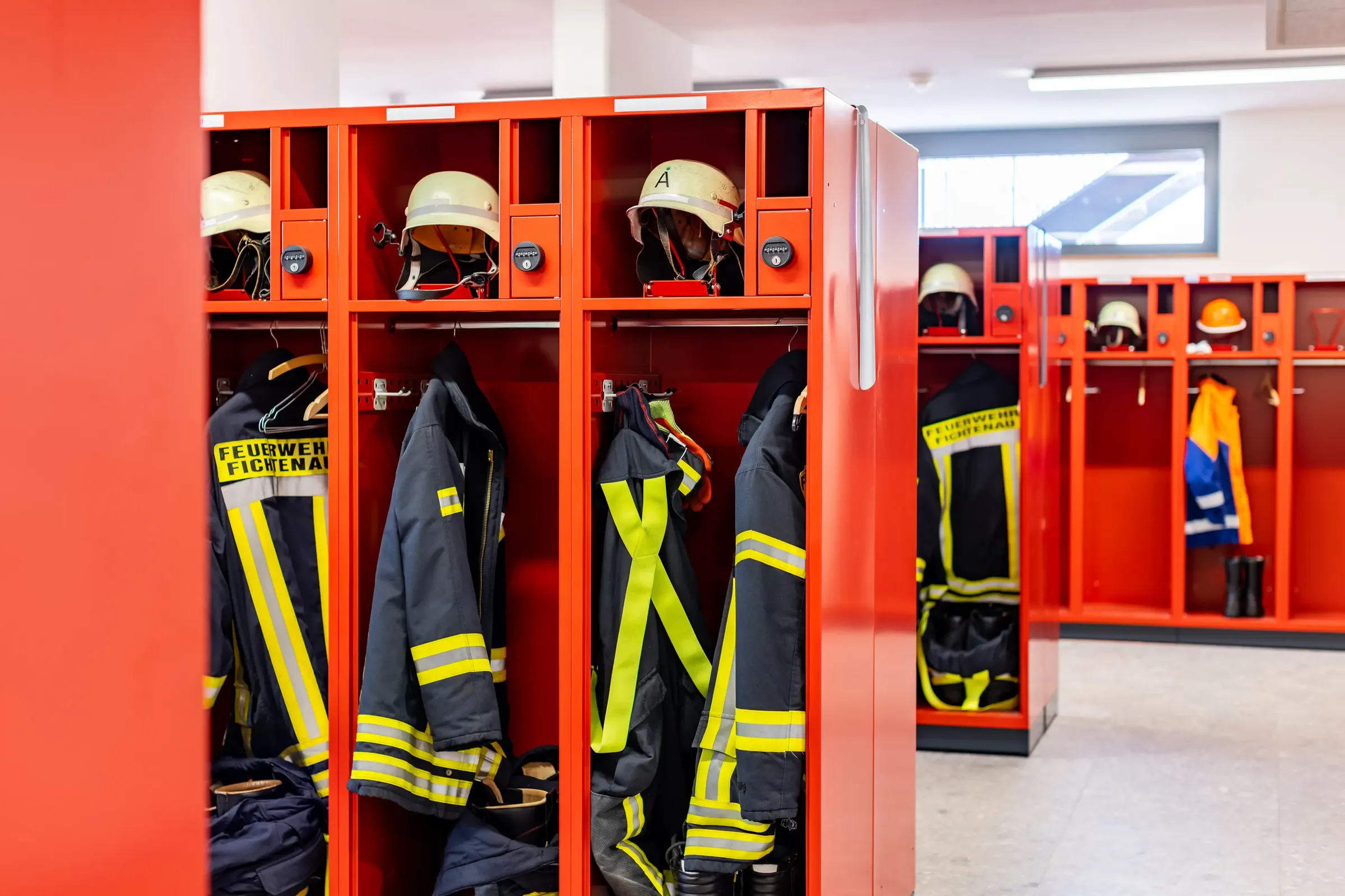 Rote Feuerwehrspinde von Eurobox mit Einsatzkleidung und Helmen