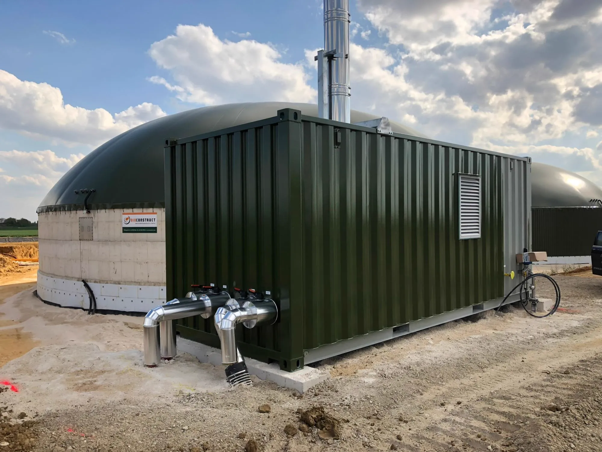 Grüner HeizMax-Heizcontainer mit Schornstein an einer Biogasanlage