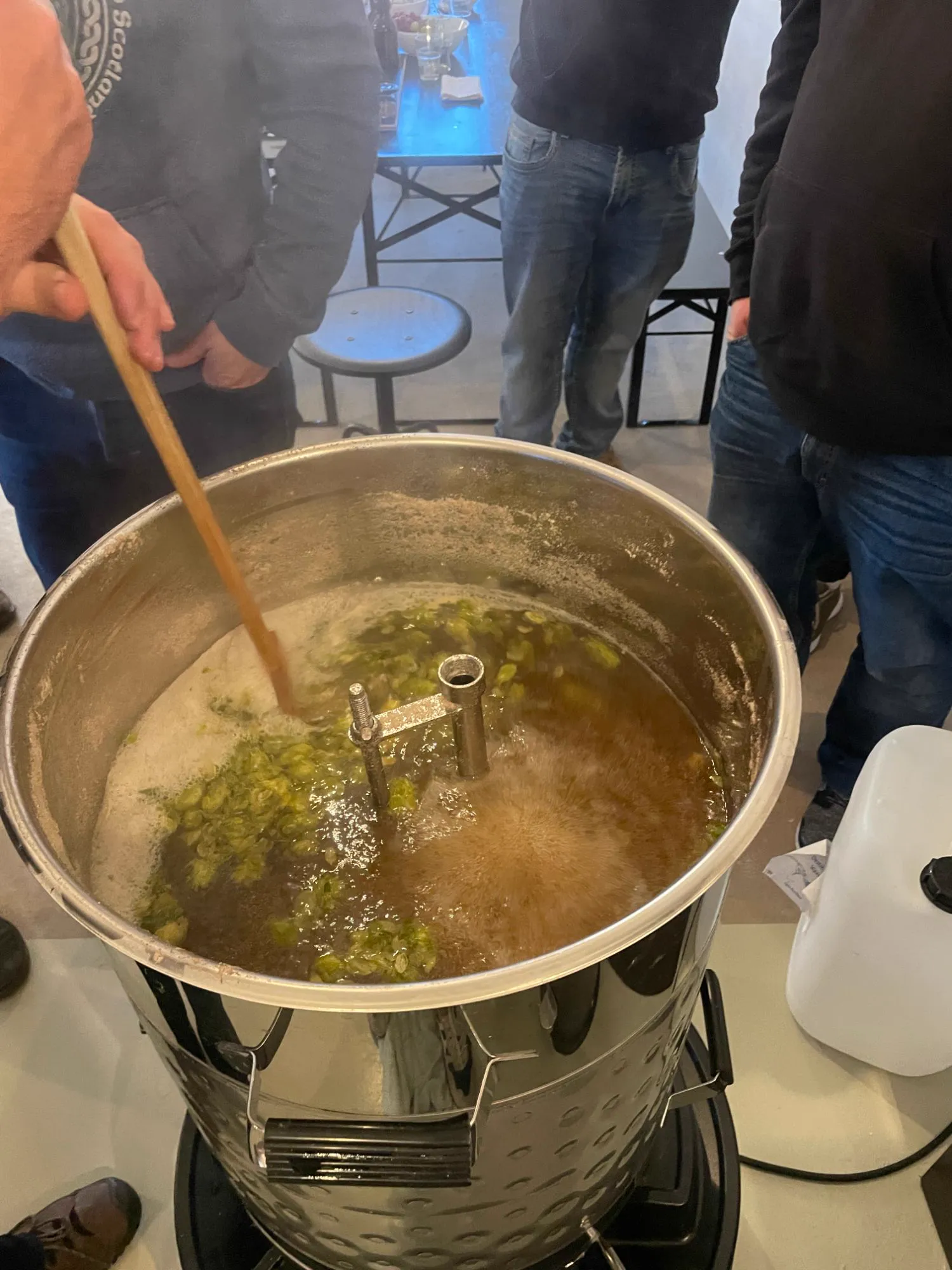 Hopfen wird in die kochende Würze gerührt